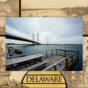May include: A wooden picture frame with a photo of a bridge over water. The frame is decorated with engraved images of buildings and a sign that says "DELAWARE".