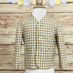Op de afbeelding: Een witte blazer met een bruin geometrisch patroon. De blazer heeft een V-hals en vier witte knopen.