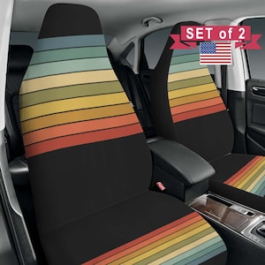 May include: A set of two black car seat covers featuring horizontal stripes in muted shades of blue, green, yellow, orange, and red. The upper portion of the covers displays the striped pattern, while the lower section is solid black. Text reads SET of 2.