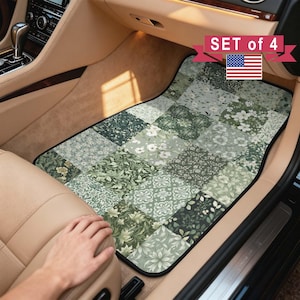 May include: A set of four car floor mats featuring a patchwork design of various green and white floral and botanical patterns. The mats are installed in the footwell of a vehicle with tan interior upholstery and include a US flag graphic.