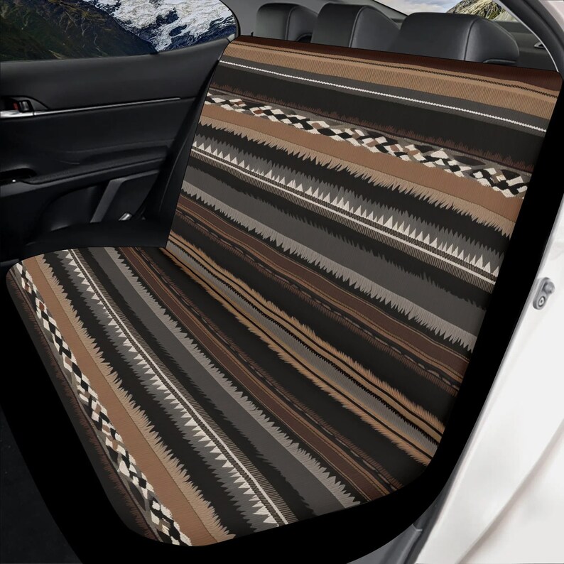 May include: Car seat cover with a geometric pattern in shades of brown, black, gray, and white. The design features a mix of stripes and zigzag patterns, creating a textured appearance. The cover is shown installed in a car, with the seat visible.