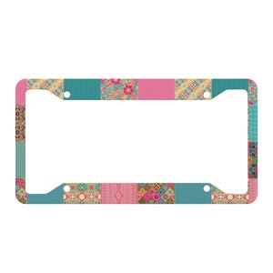 Peut inclure: Un cadre de plaque d'immatriculation rectangulaire arborant un motif patchwork vibrant. Le design se compose de blocs alternés dans des tons de bleu sarcelle, rose et jaune, présentant divers motifs floraux, géométriques et rayés sur toute la surface.