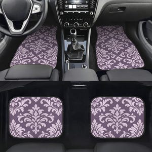 May include: A set of four car floor mats featuring a repeating light purple damask pattern on a darker purple background. The mats are shown installed in the front footwells of a vehicle and as a separate pair of rectangular rear floor mats.