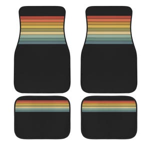 May include: A set of four black car floor mats featuring a horizontal striped pattern in muted shades of red, orange, yellow, green, and blue. The two larger front mats and two smaller rear mats all display the same retro-inspired color block design.