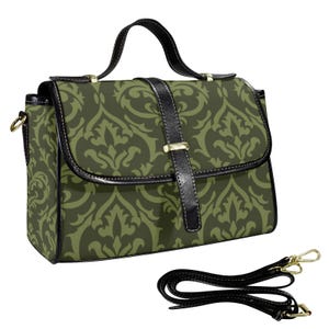 Może przedstawiać: Oliwkowo-zielona torba z czarnym skórzanym paskiem i uchwytem. Torba ma powtarzający się wzór kwiatowy i złote okucia. Zawiera odpinany pasek na ramię.