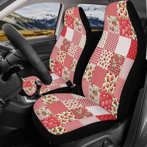 May include: Car seat covers with a patchwork design featuring red strawberries, gingham, and polka dots on a white background. The covers are set against a black base, with a matching steering wheel cover.