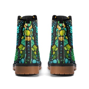 May include: A pair of black ankle boots with a green, blue, and yellow mosaic pattern. The boots have a brown sole and black laces.