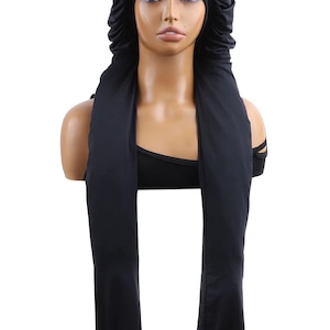 May include: A black satin bonnet with a wide, flowing scarf attached. The bonnet covers the head and has a gathered edge. The scarf drapes down the front. The item is displayed on a mannequin.