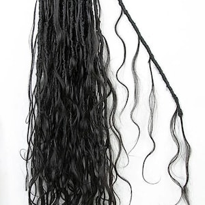 May include: Black synthetic dreadlocks with wavy ends. The dreadlocks are attached to a black string and are hanging against a white background. The hair extensions are a dark, solid color.