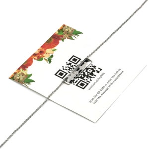 May include: A silver necklace with a rectangular pendant featuring a QR code and the text "shorturl.at/mpNR4". The text below the QR code reads "Scan the QR Code or enter the link to hear the message of this soundwave".