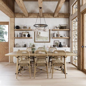 May include: A dining room with a large wooden table and six woven chairs. The room features wooden beams, shelves with decor, and a hanging light fixture. The walls are white, and the floors are light-colored wood.