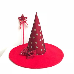 May include: A red witch hat with gold and silver polka dots, a red bow with sequins, and a red star-shaped wand with a white and red ribbon.
