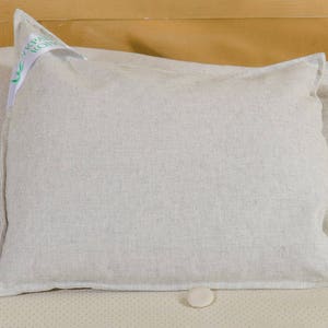 Puede incluir: Dos fundas de almohada de lino blanco con una peque&ntilde;a etiqueta blanca en una funda de almohada que dice "Organic Cotton".