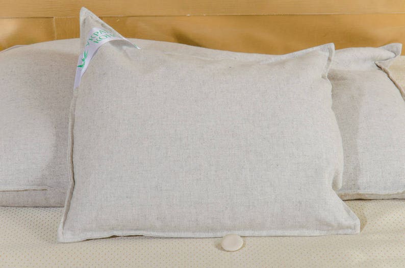 Puede incluir: Dos fundas de almohada de lino blanco con una peque&ntilde;a etiqueta blanca en una funda de almohada que dice "Organic Cotton".