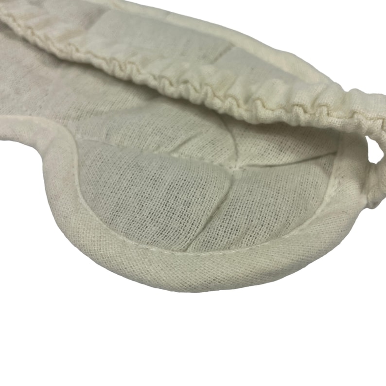 Puede incluir: Una m&aacute;scara para dormir de algod&oacute;n blanco con un dise&ntilde;o acolchado. La m&aacute;scara est&aacute; dise&ntilde;ada para bloquear la luz y ayudarte a dormir.