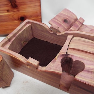 May include: A wooden box with a hinged lid, a heart-shaped cutout, and a brown felt lining. The box is made of cedar wood and has a natural wood finish.