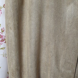 May include: Close-up of a brown fabric with a herringbone pattern. The fabric has a subtle sheen and a slightly textured surface.