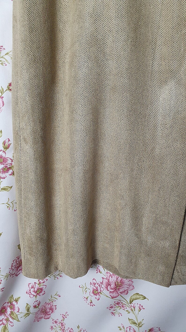 May include: Close-up of a brown fabric with a herringbone pattern. The fabric has a subtle sheen and a slightly textured surface.