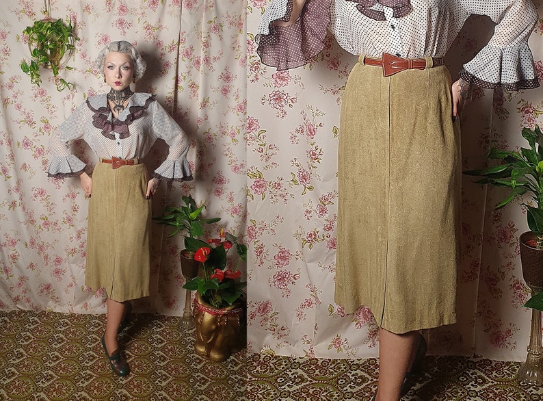 May include: A brown corduroy skirt with a brown leather belt. The skirt is knee-length and has a straight silhouette.