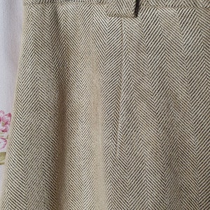 May include: A pair of brown herringbone patterned pants with a single button closure at the waist.