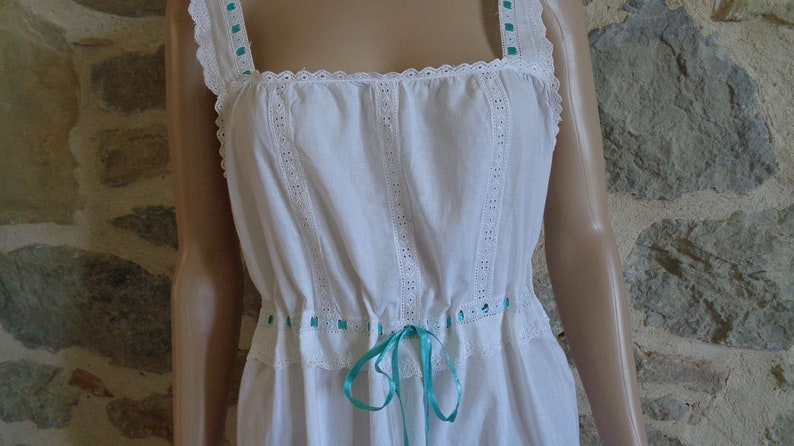 White cotton nightdress or full slip trimmed with broderie anglaise threaded with turquoise ribbon