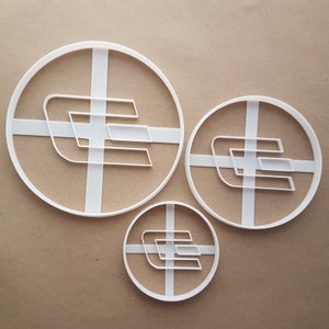 May include: Three white plastic cookie cutters in different sizes, each featuring a stylized letter E logo.