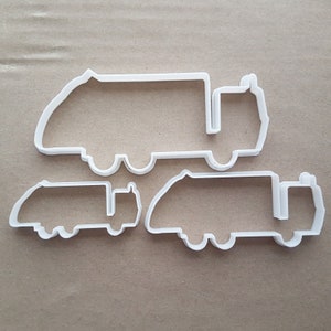 Puede incluir: Tres cortadores de galletas de plástico blanco con forma de camión de basura. Los cortadores son de diferentes tamaños.