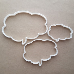 May include: Three white plastic cookie cutters shaped like speech bubbles. The largest bubble is at the top left, the medium bubble is at the bottom right, and the smallest bubble is at the top right.