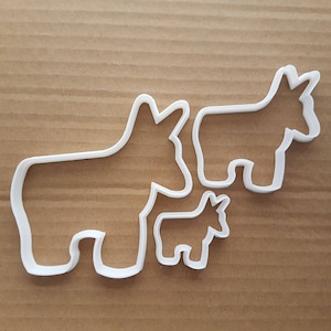 Puede incluir: Tres cortadores de galletas de plástico blanco con forma de burro, de diferentes tamaños. El burro más grande está a la derecha, el burro de tamaño mediano está a la izquierda y el burro más pequeño está en el centro.