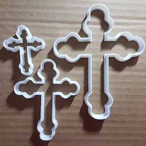 Può includere: Tre stampini per biscotti in plastica bianca a forma di croce. La croce più grande è alta circa 18 cm e la croce più piccola è alta circa 8 cm.