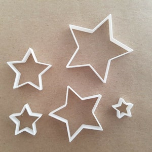 May include: Set of five white plastic star-shaped cookie cutters of varying sizes.