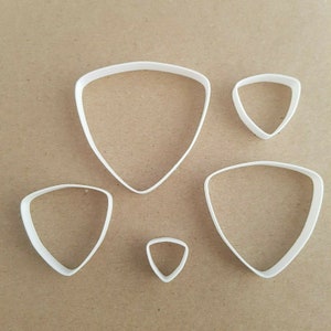 May include: Set of five white plastic triangle cookie cutters of varying sizes.