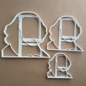 May include: Three white plastic cookie cutters shaped like the profile of William Shakespeare. The largest cutter is approximately 6 inches tall, the middle cutter is approximately 4 inches tall, and the smallest cutter is approximately 3 inches tall.