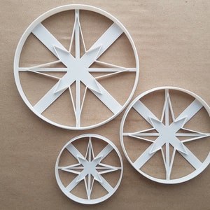 Può includere: Tre tagliabiscotti in plastica bianca a forma di stella a otto punte. I tagliabiscotti sono di diverse dimensioni.