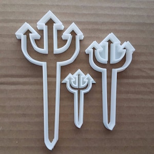 Könnte beinhalten: Drei weiße Plastik-Ausstecher in Form von Dreizacken. Der größte Dreizack ist etwa 25 cm hoch, der mittlere Dreizack ist etwa 15 cm hoch und der kleinste Dreizack ist etwa 10 cm hoch.