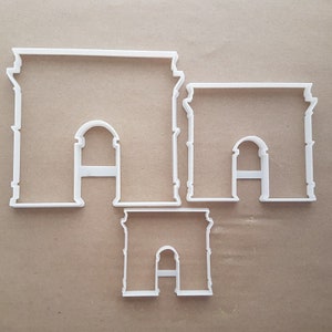 Può includere: Tre tagliabiscotti in plastica bianca a forma di Arco di Trionfo a Parigi, Francia. I tagliabiscotti sono di dimensioni diverse, con il più grande in alto nell'immagine e il più piccolo in basso.