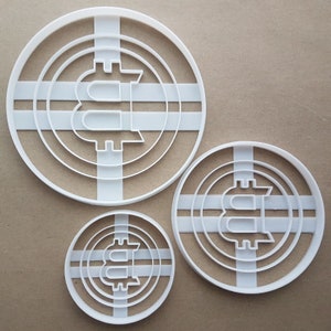 May include: Three white plastic cookie cutters shaped like a Bitcoin coin. The cutters are different sizes, with the largest cutter being about 5 inches in diameter.