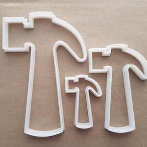 May include: Three white plastic cookie cutters shaped like hammers of different sizes.