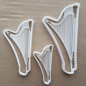 Può includere: Tre tagliabiscotti in plastica bianca a forma di arpe. I tagliabiscotti sono di diverse dimensioni.