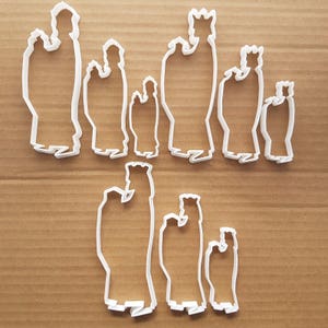 Può includere: Tagliabiscotti in plastica bianca a forma di persone, alcuni con corone, per fare biscotti di Natale.