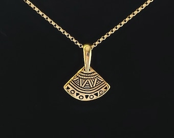 May include: A gold necklace with a geometric pendant. The pendant is shaped like a fan and has a detailed design.
