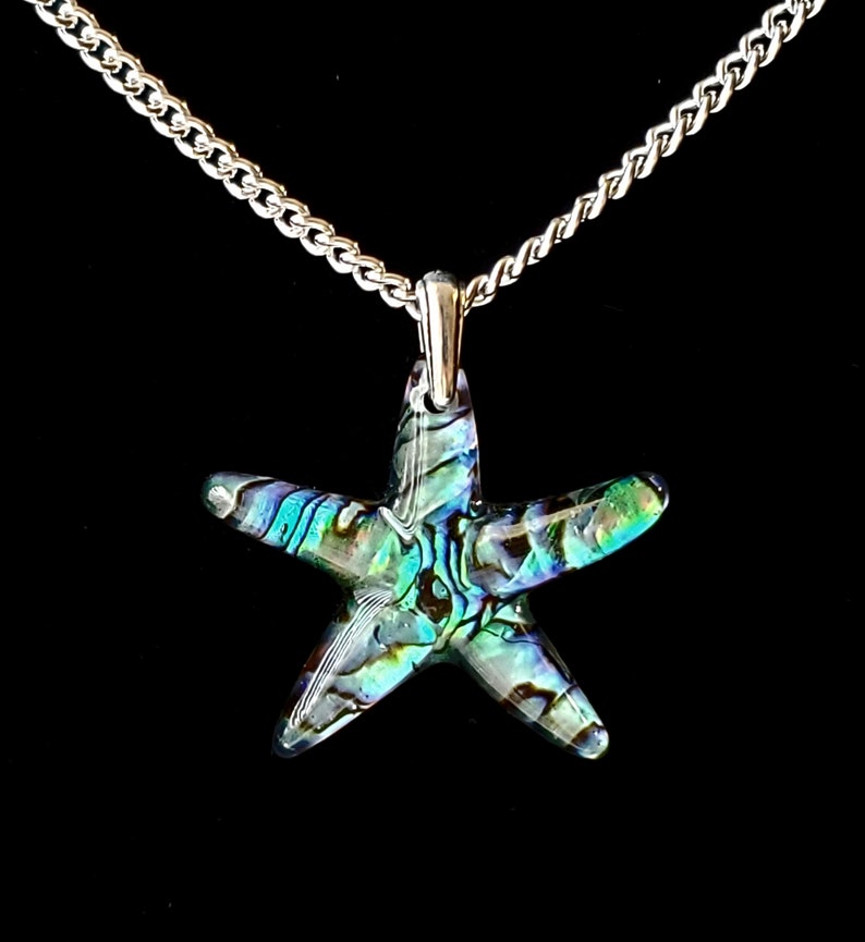 May include: A silver chain necklace with a iridescent abalone shell starfish pendant.