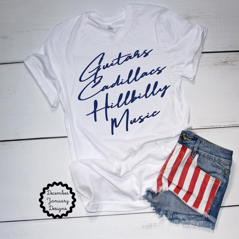 Puede incluir: Camiseta blanca con texto azul que dice "Guitars Cadillacs Hillbilly Music".