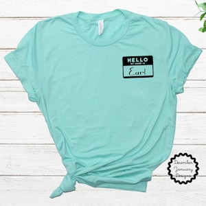May include: A turquoise t-shirt with a black name tag that says "Hello, my name is Earl".