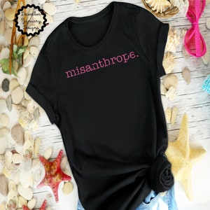 May include: Black t-shirt with the word "misanthrope" printed in pink on the front.