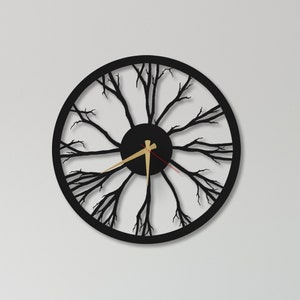 May include: A black wall clock with a tree branch design. The clock is hanging on a white wall above a dining table with six chairs.