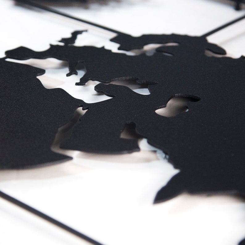 May include: A black metal world map wall decor with a cutout design. The map is mounted on a white background.
