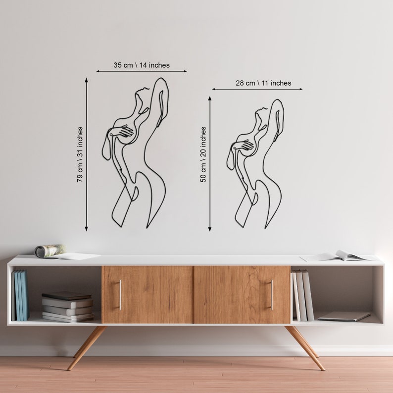 May include: Two black line art wall decals of a woman's body in different sizes. The larger decal is 31 inches tall and 14 inches wide. The smaller decal is 20 inches tall and 11 inches wide.
