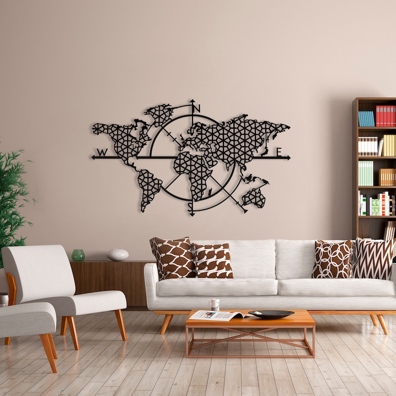 May include: Black metal wall art featuring a world map with a compass design. The map is surrounded by a circle with compass points N, S, E, and W. The map is detailed and intricate, with a geometric pattern.