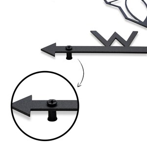 May include: Close-up of a black metal arrow with a screw and a black metal cap. The arrow is attached to a metal rod. The arrow is pointing to the left.